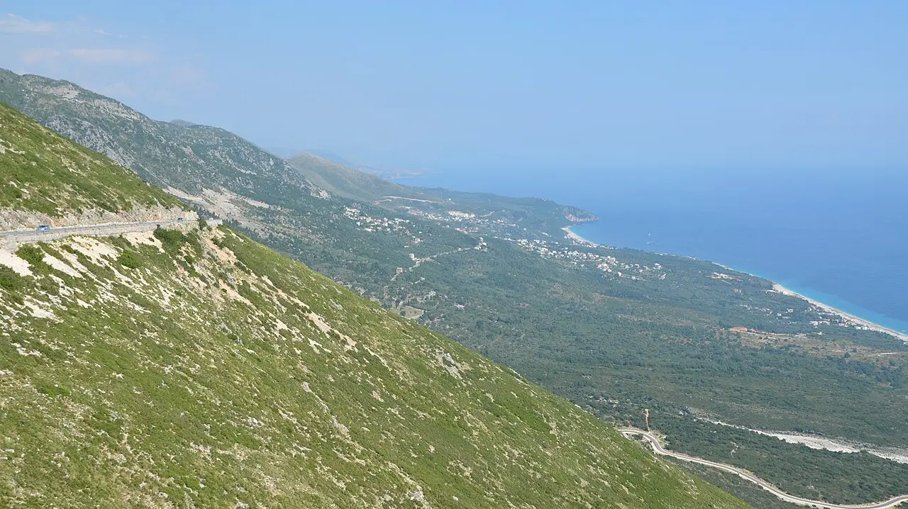 The Albanian Riviera coastline near Dhermi, with turquoise coves and the Ceraunian Mountains dropping to the Ionian Sea